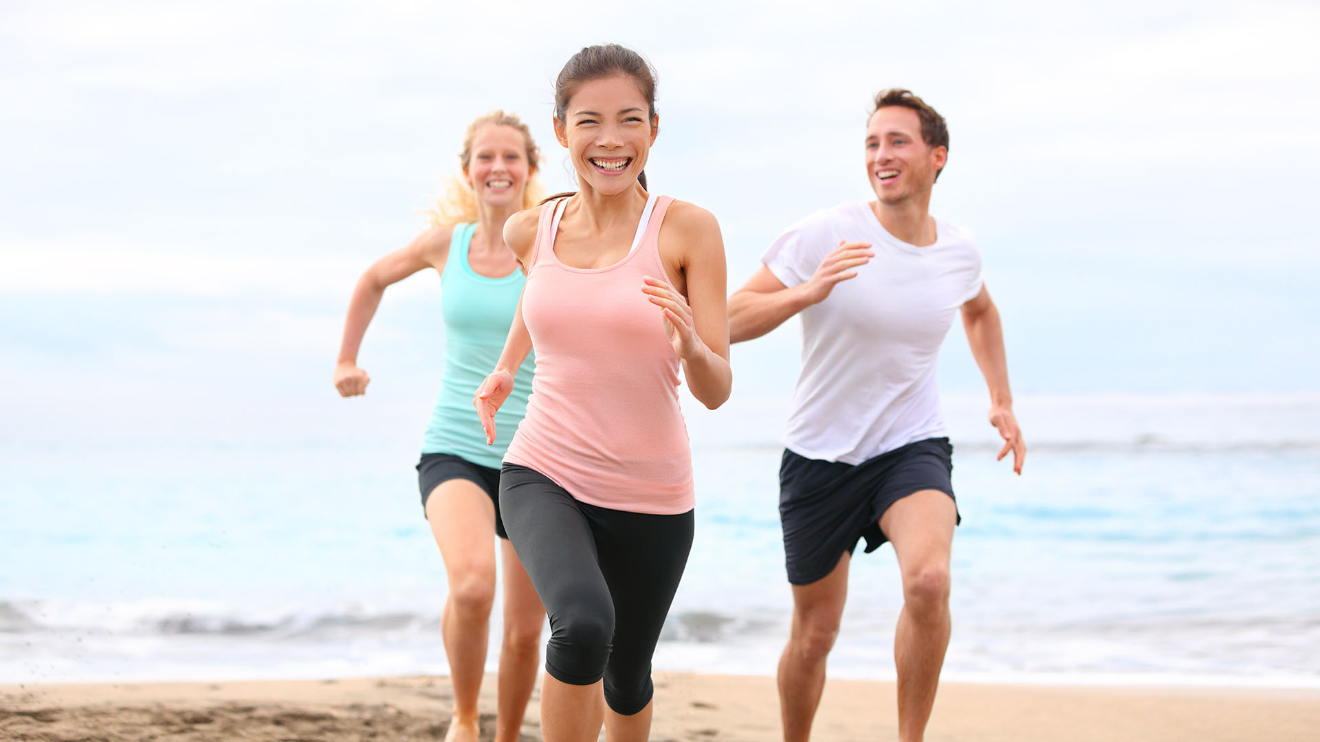 Плотный активный. Активный образ жизни. Люди бегут по пляжу. Друзья на пробежке. Группа людей бегают.